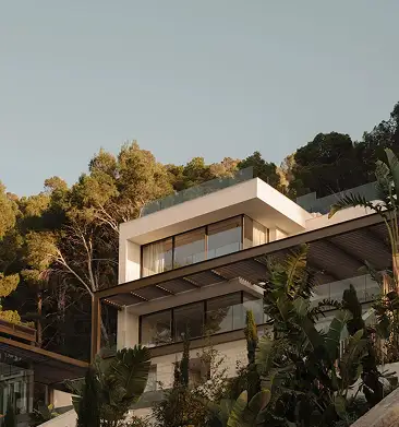 Modern residence exterior nestled among trees at dusk